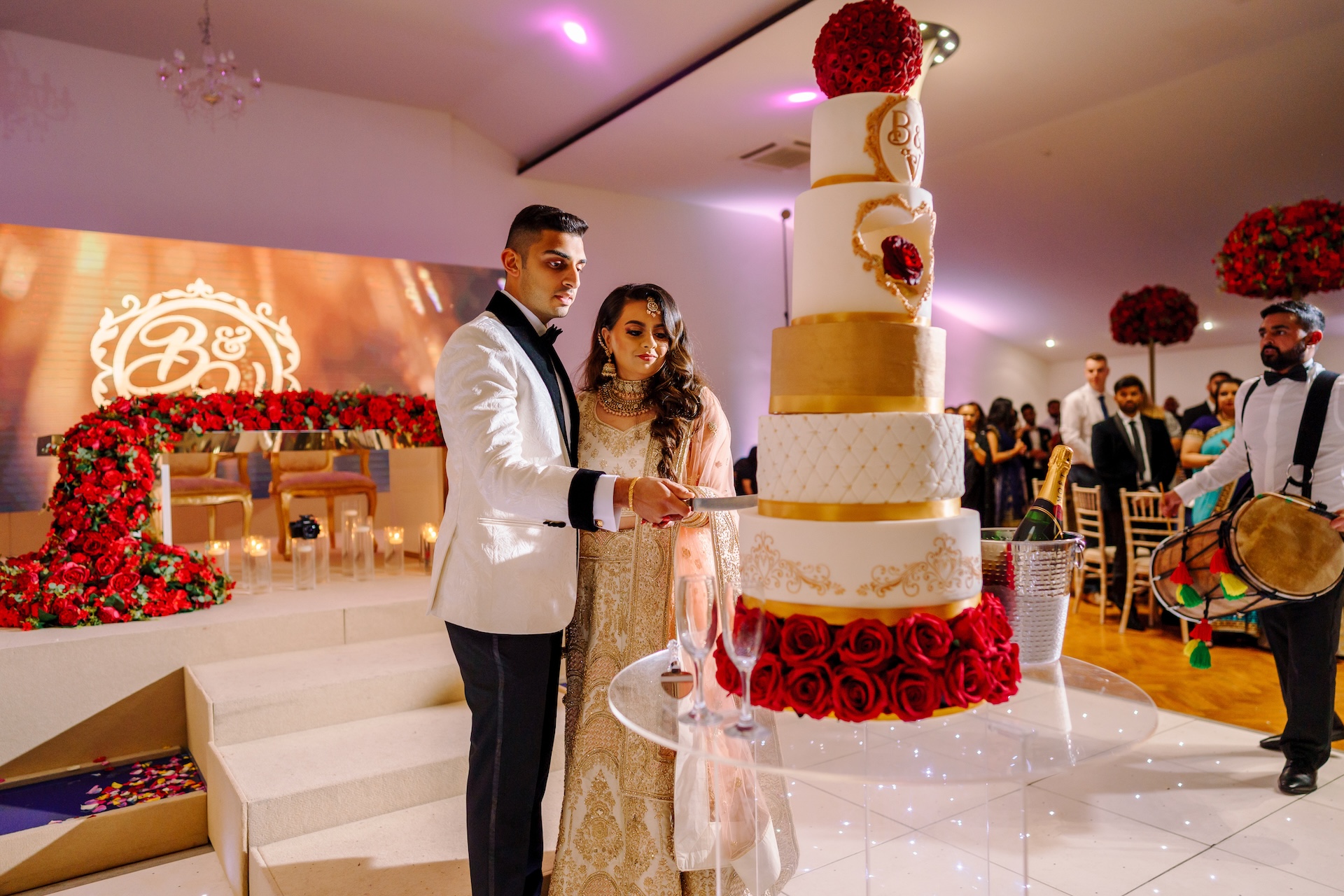 A grand Indian wedding cake decorated in vibrant red, gold, and white, symbolising celebration, love, and tradition.
