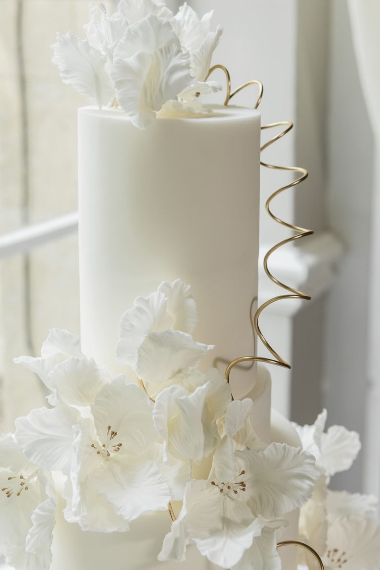 White and gold wedding cake topper displayed at Stapleford Park near Melton Mowbray, Leicestershire.