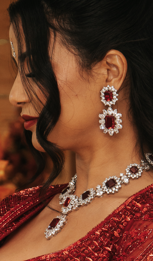 Bride wearing elegant red and diamanté jewellery that perfectly complements her red wedding outfit during a Leicestershire wedding in the East Midlands.
