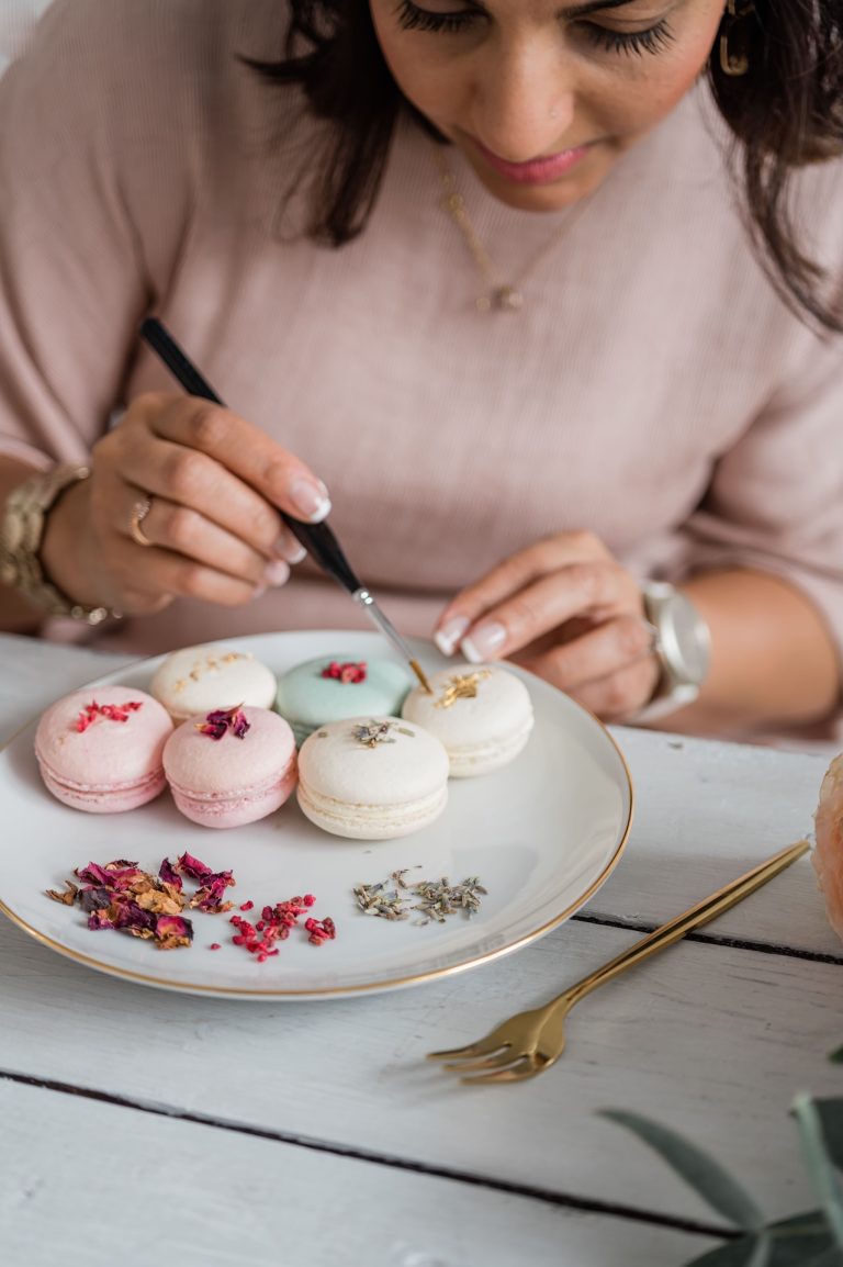 Dimple from Sugar Creations by Dimple adding the finishing touches to elegant pastel French macarons — handmade with love in Leicestershire.