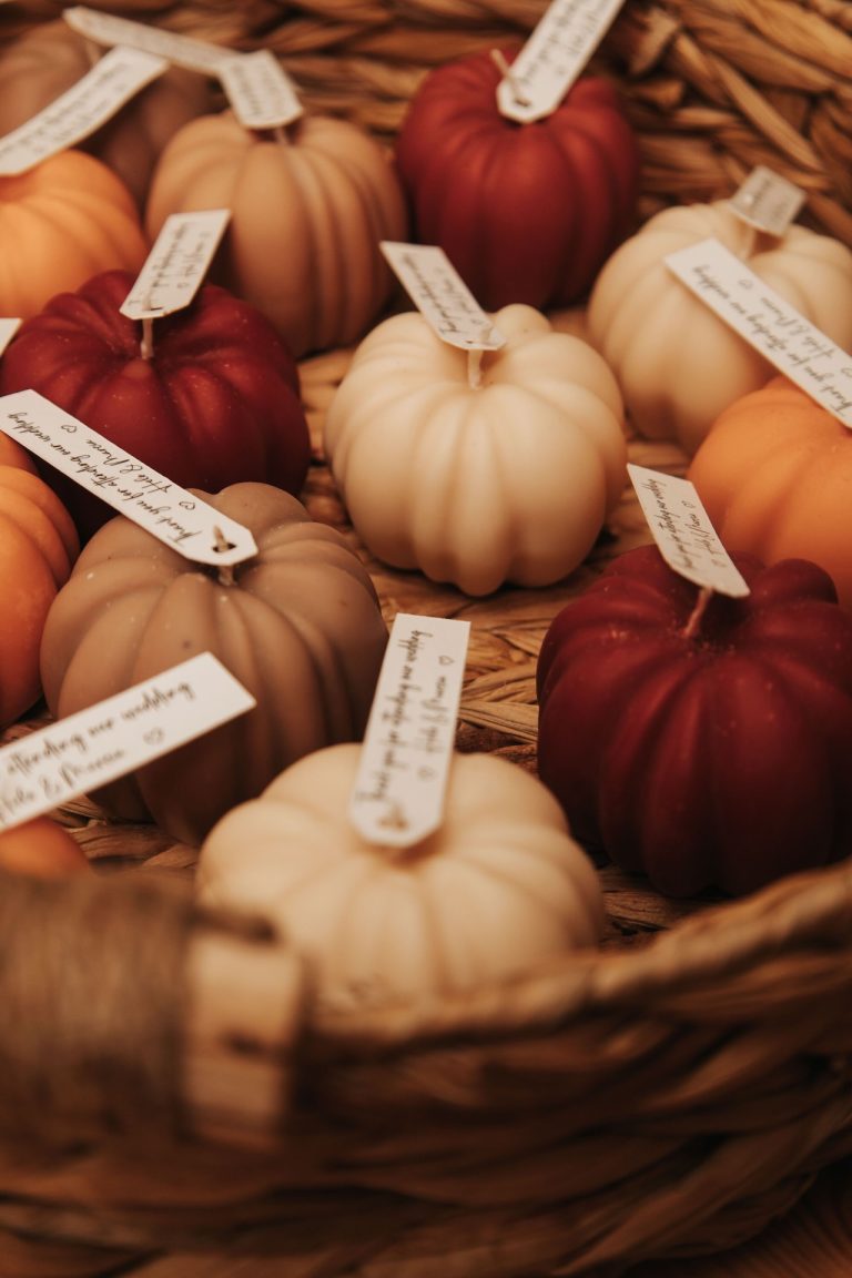 Pumpkin-shaped candles and autumn-coloured decorations arranged in a rustic straw basket for a Leicestershire wedding in the East Midlands.