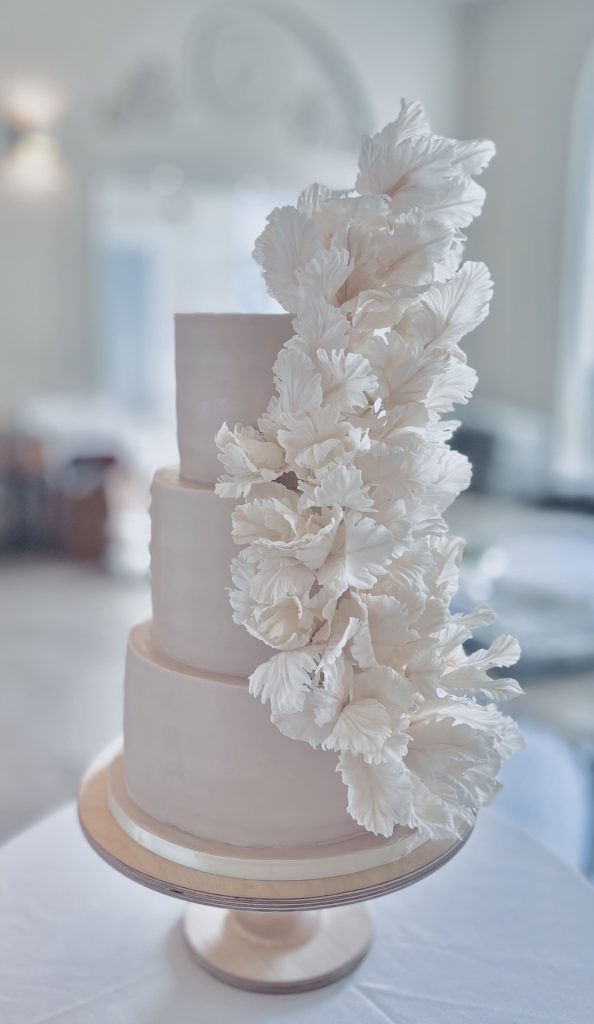 Luxury wedding cake supplier Charnwood - Soft nude three-tier wedding cake with flowing handcrafted sugar petals, designed by Sugar Creations by Dimple in Leicestershire. Exceptional Wedding Cakes in Loughborough
