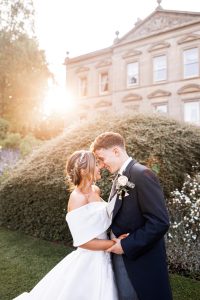 Grace and Dan standing lovingly together in front of Kilworth House in Leicestershire on their wedding day.